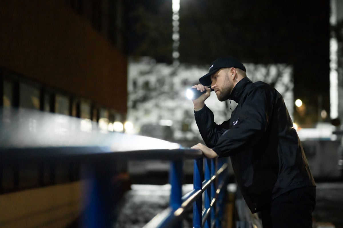 security guard checking building with a flashlight